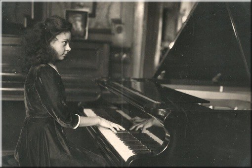 Betty Verlooy au piano dans le salon de la maison familiale, g d’environ 12 ans.